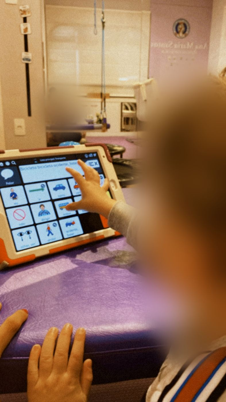 Criança usando o sistema de comunicação no tablet durante a sessão